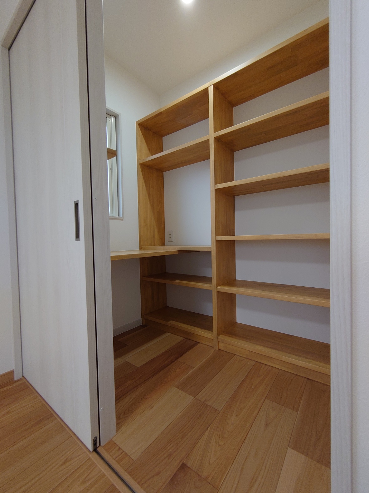 寝室横の書斎スペース、壁一面に施された造作棚は使い勝手も〇